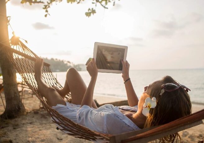 A woman laying in a hammock on the beach